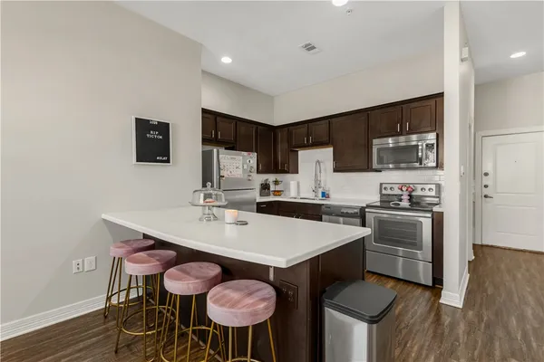 a kitchen with a dining table chairs and stainless steel appliances
