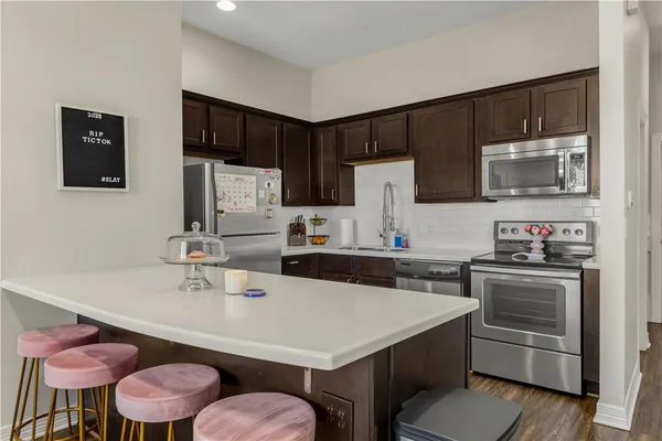 a kitchen with a sink refrigerator and microwave