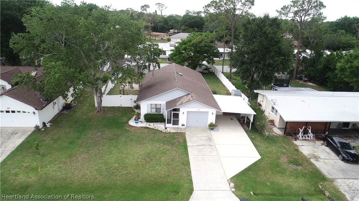 113 Longview Road Sebring, FL 33870 - Photo 2 of 31 an aerial view of a house with swimming pool and trees all around