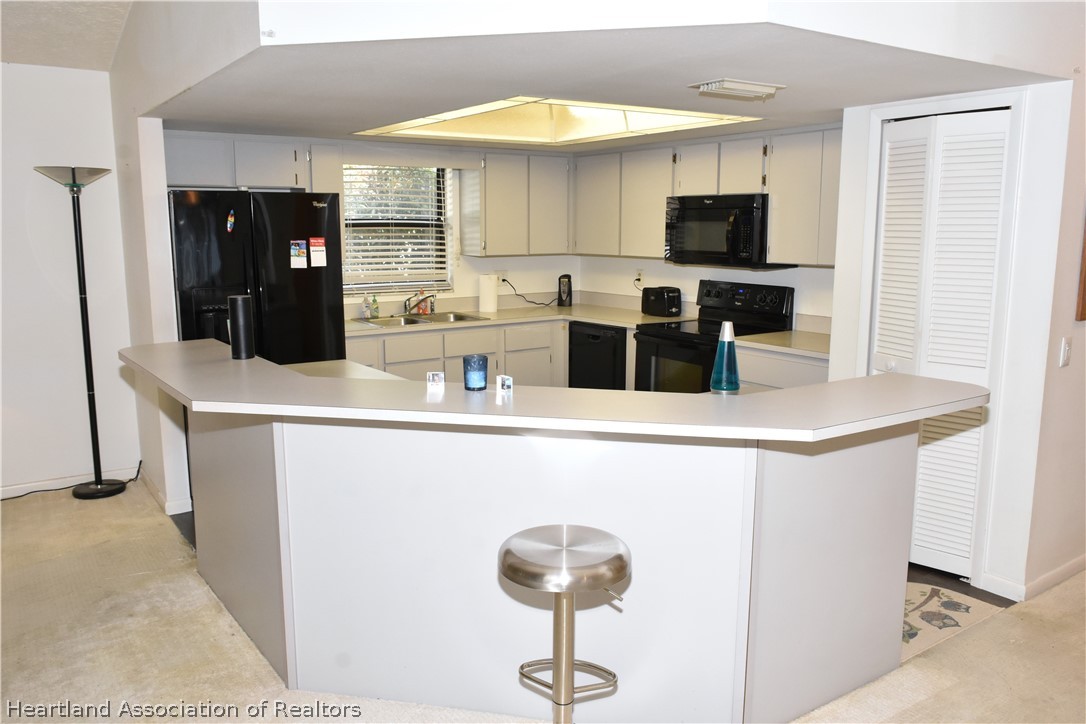113 Longview Road Sebring, FL 33870 - Photo 5 of 31 a kitchen with stainless steel appliances a stove refrigerator and a microwave