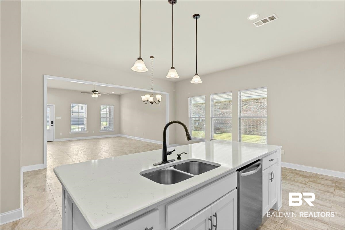 1112 Stella Road Foley, AL 36535 - Photo 32 of 33 Kitchen featuring an island with sink, a chandelier, dishwasher, light stone countertops, and open floor plan