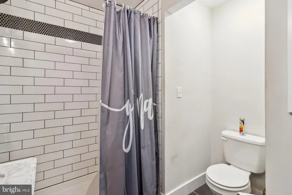 a white toilet sitting next to a shower curtain