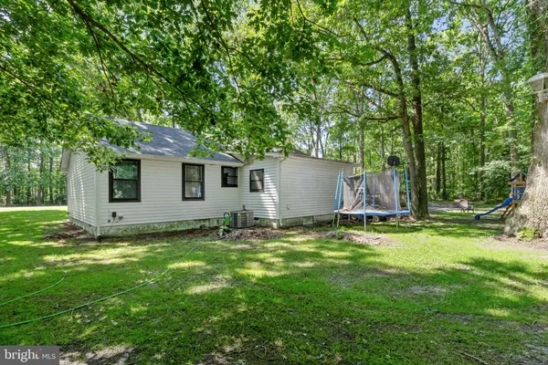 a front view of a house with a yard and trees