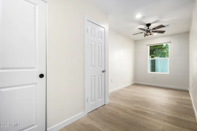 an empty room with windows and fan