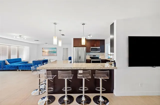 a kitchen with stainless steel appliances kitchen island granite countertop a stove a sink and a microwave