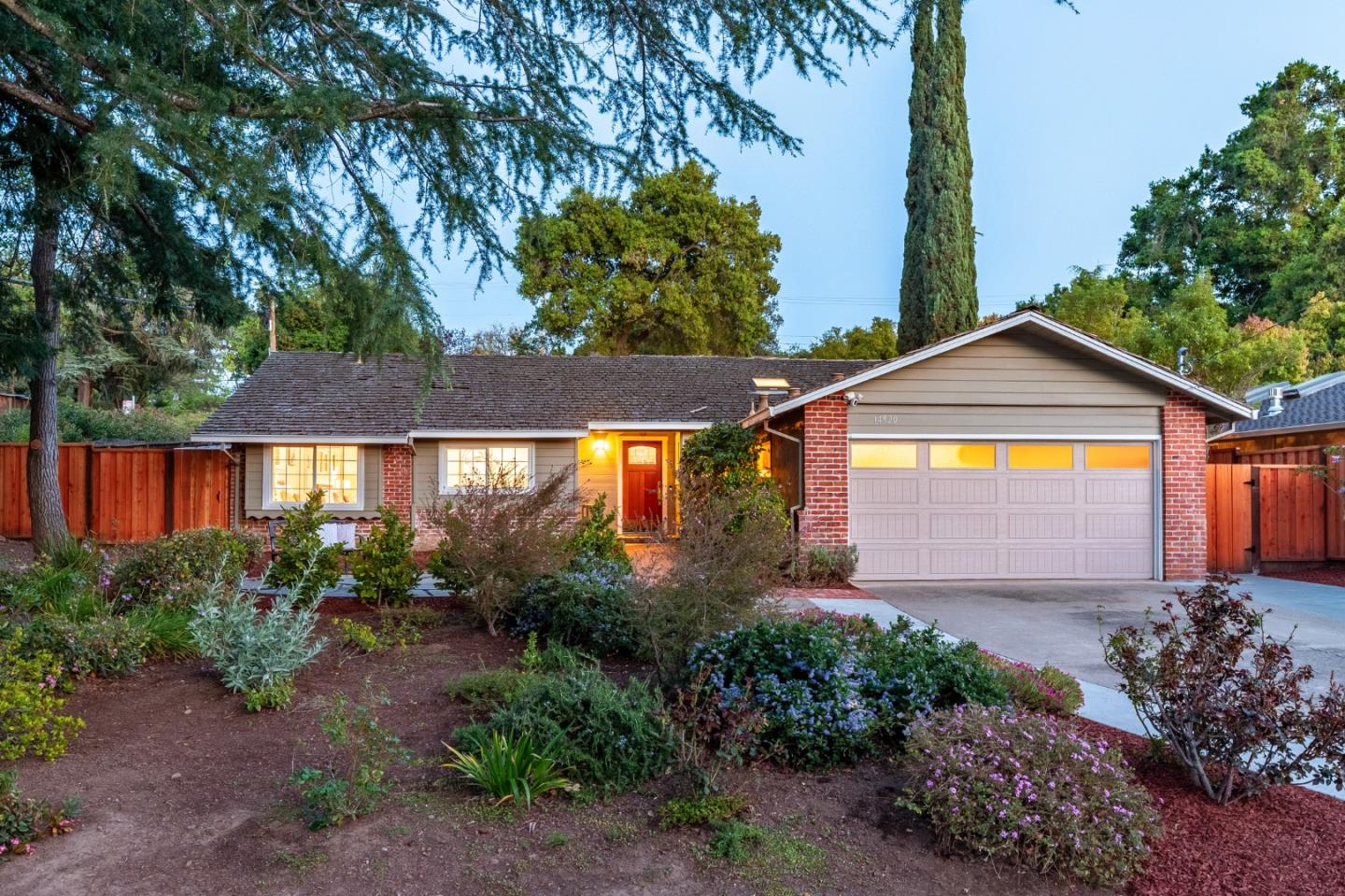 a view of a house with large windows and a table and chairs under an umbrella