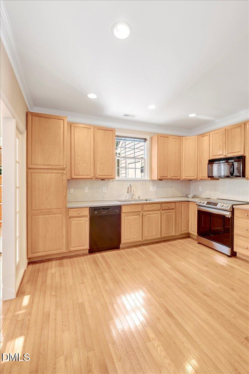6021 Four Townes Lane Raleigh, NC 27616 - Photo 22 of 49 a large kitchen with stainless steel appliances double vanity and a window