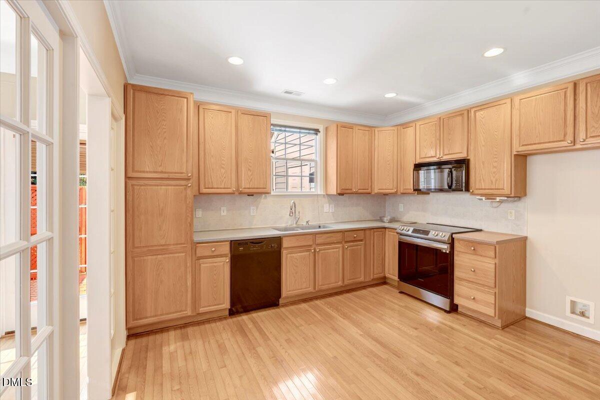 6021 Four Townes Lane Raleigh, NC 27616 - Photo 23 of 49 a kitchen with granite countertop a stove top oven sink and cabinets