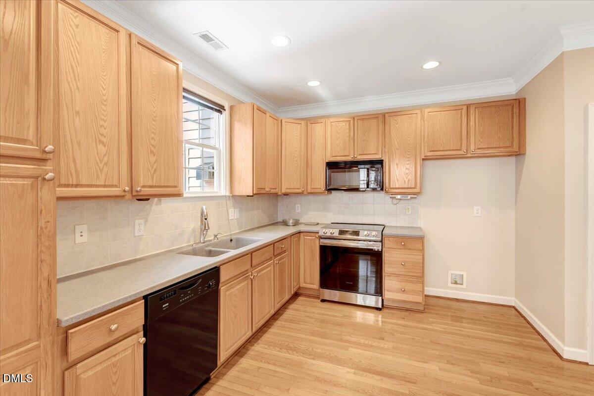 6021 Four Townes Lane Raleigh, NC 27616 - Photo 24 of 49 a kitchen with stainless steel appliances granite countertop a stove a sink and a white cabinets
