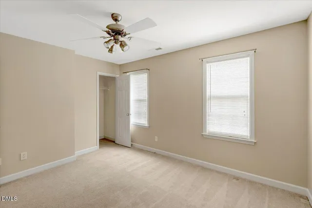 an empty room with a window and a ceiling fan