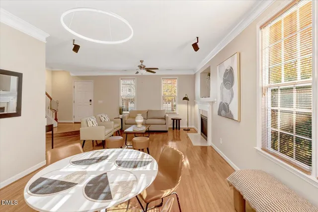 a living room with furniture a dining table and a large window