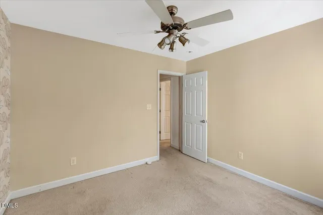 an empty room with a ceiling fan and a fan