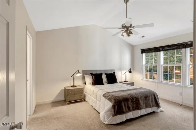 a bedroom with a bed chandelier and window