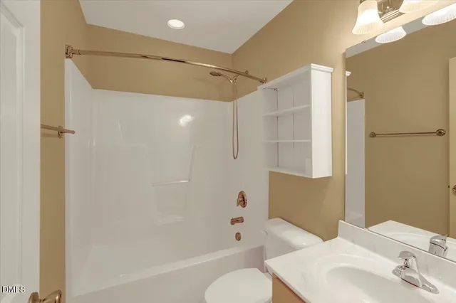 a bathroom with a bathtub shower sink vanity and toilet
