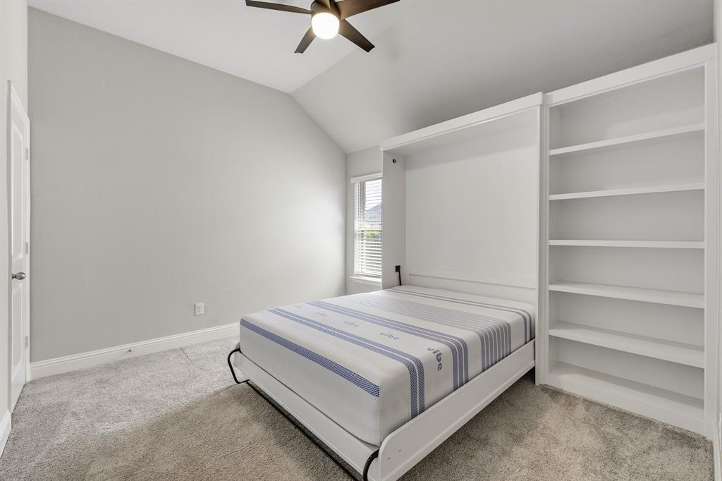 915 Timber Ridge Drive Justin, TX 76247 - Photo 28 of 39 Room featuring a built-in Murphy bed, integrated shelving, vaulted ceiling, and a ceiling fan