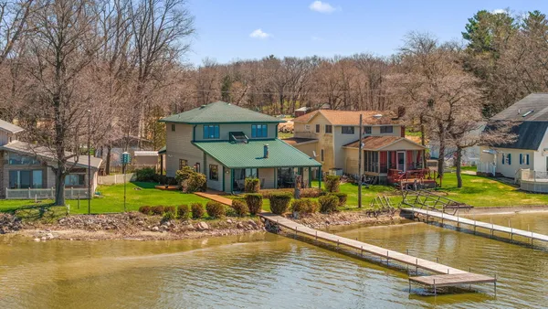 a view of a house with swimming pool next to a yard