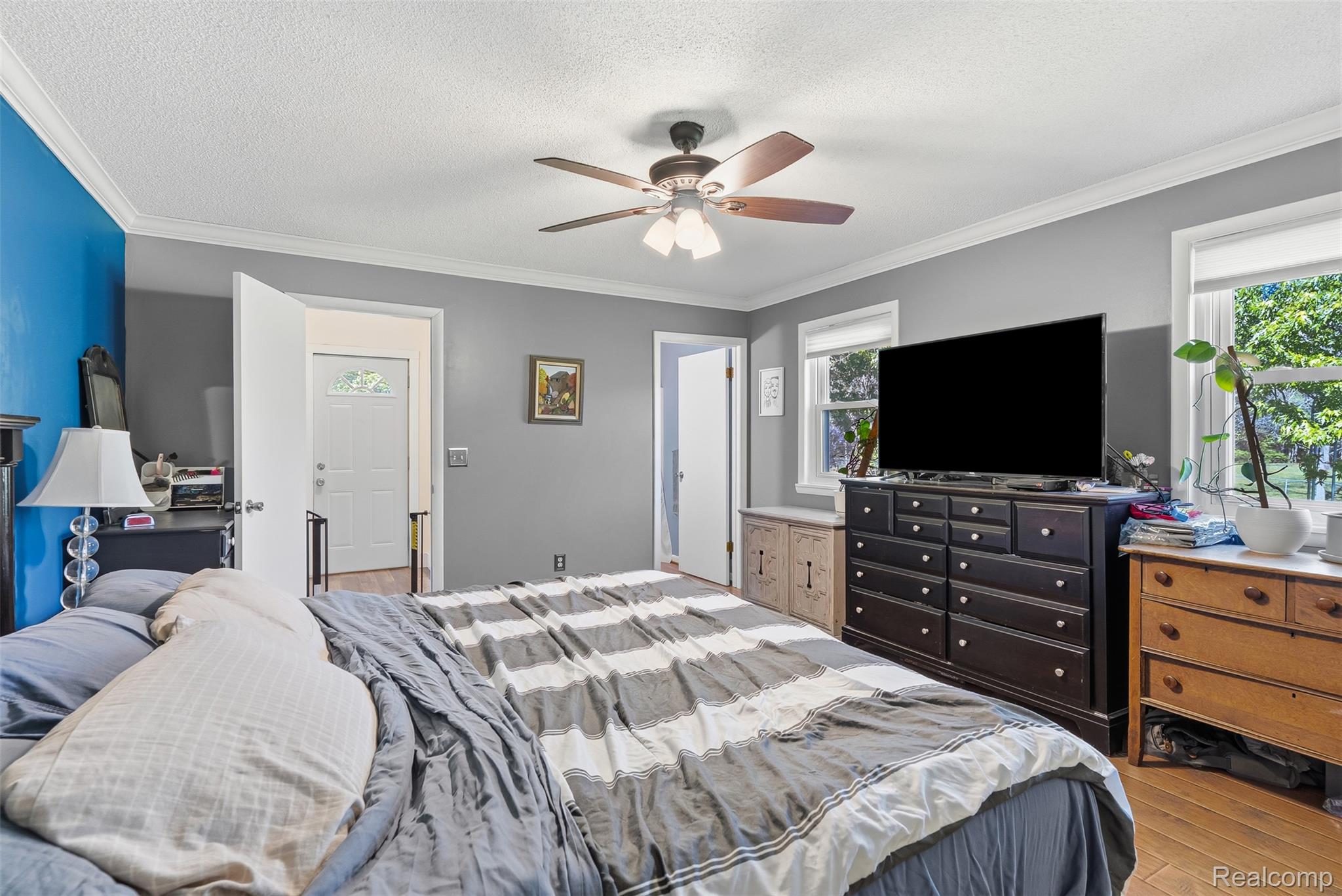 14433 Tuscola Road Clio, MI 48420 - Photo 19 of 43 Bedroom featuring light wood-type flooring, a ceiling fan, crown molding, and a textured ceiling