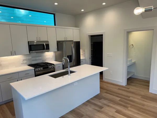 a kitchen with stainless steel appliances a stove refrigerator sink and cabinets