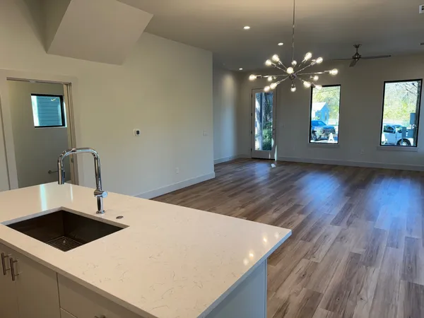 a kitchen with a sink a counter space and wooden floor
