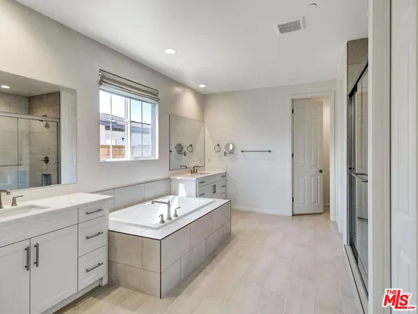 a bathroom with a sink a tub and mirror