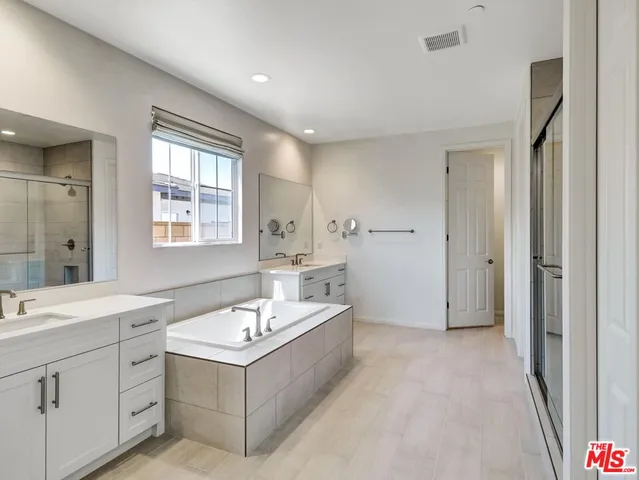 a bathroom with a sink a tub and mirror
