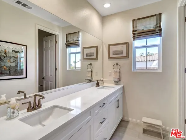 a bathroom with double sink and a mirror