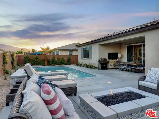 a view of a patio with couches table and chairs with wooden floor