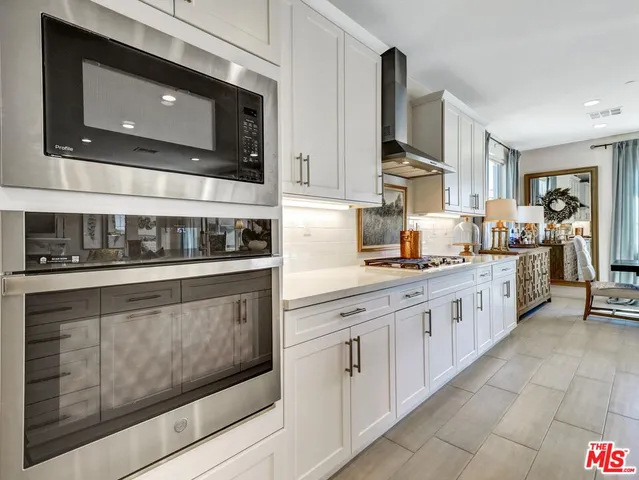 a kitchen with stainless steel appliances granite countertop a stove microwave and cabinets