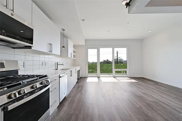 a kitchen with kitchen island white cabinets and appliances