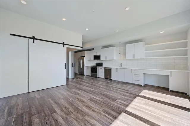 a kitchen with granite countertop a stove a sink and a refrigerator