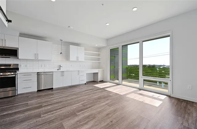 a view of a kitchen with wooden floor and electronic appliances