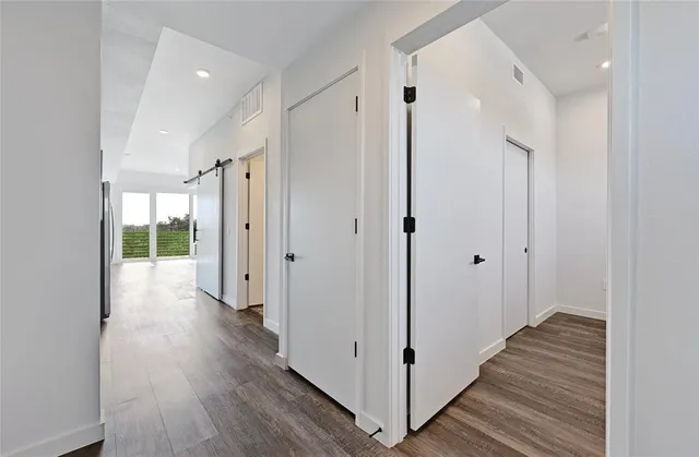 a view of empty room with wooden floor
