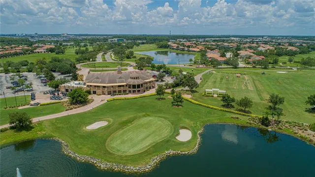 an aerial view of a residential houses with outdoor space and a lake view