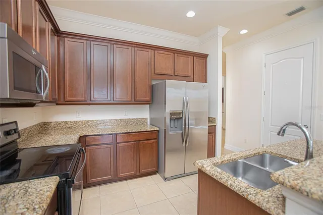 a kitchen with granite countertop a sink stainless steel appliances and cabinets