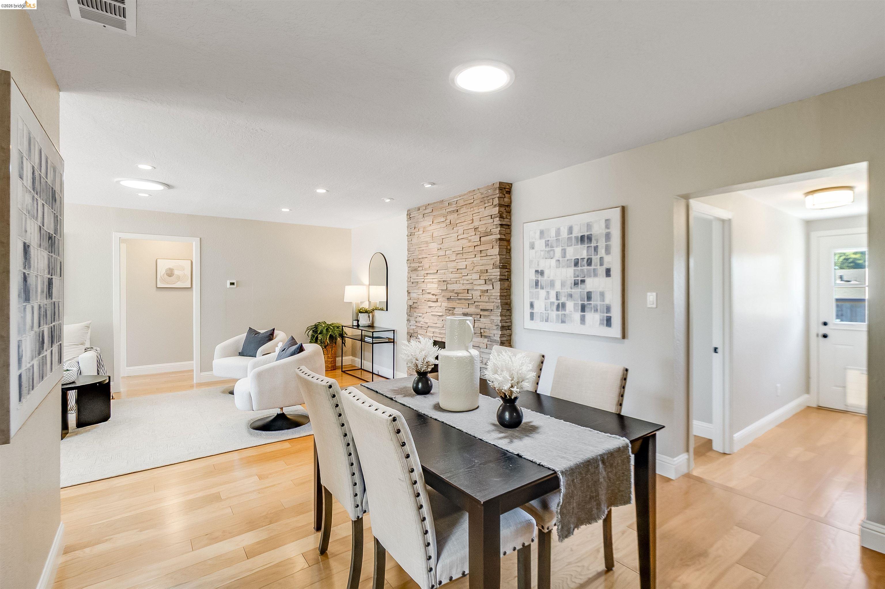 346 Valley View Road Pleasant Hill, CA 94523 - Photo 14 of 57 Open-concept living space featuring light wood-finish flooring, recessed lighting, a stone accent wall, and a bright white door