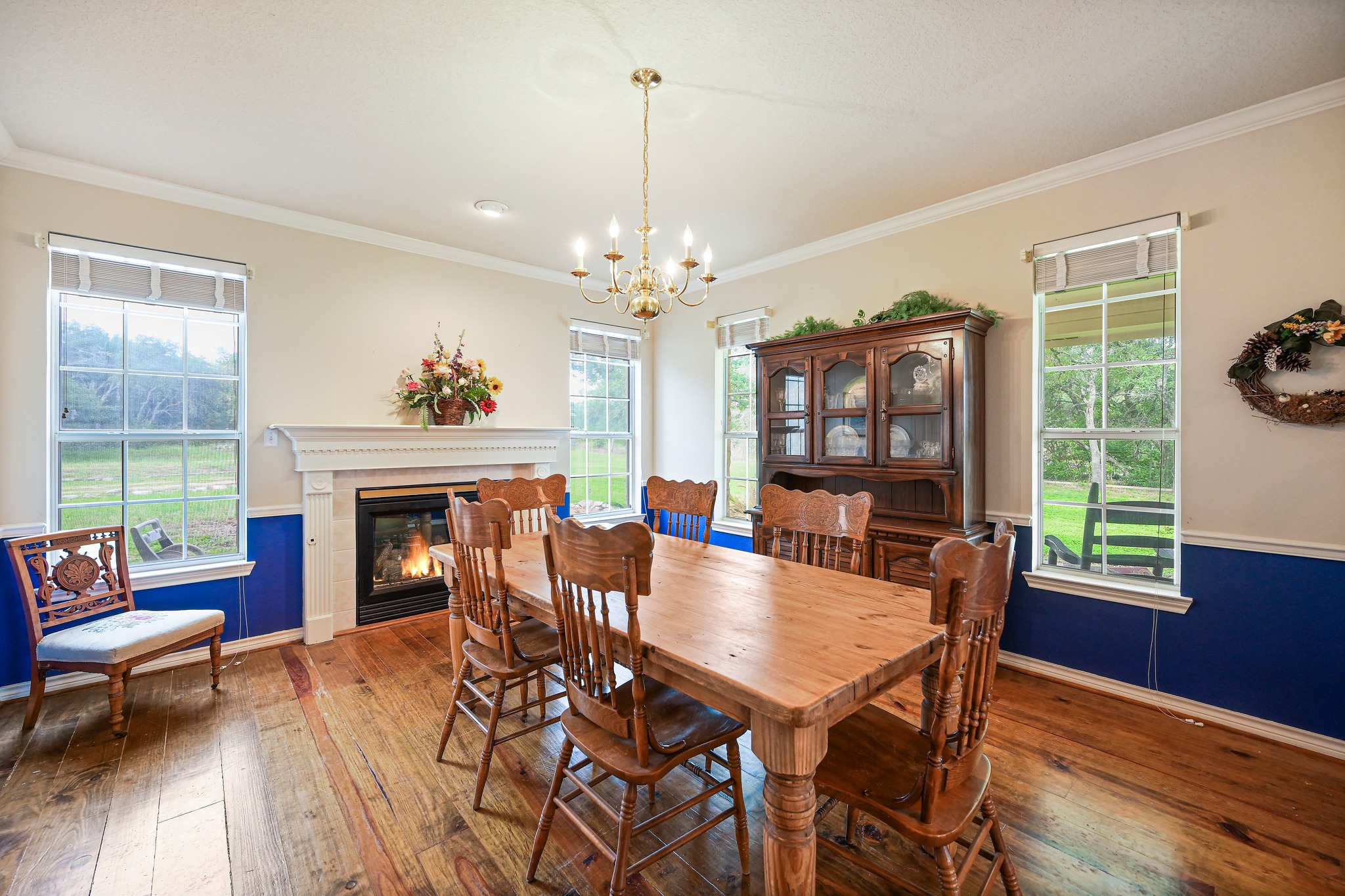 364 Nameless Road Driftwood, TX 78619 - Photo 12 of 32 Hardwood floors and a cozy fireplace define this inviting dining area. Notice the chair molding in this room and the detail on the fireplace mantle.