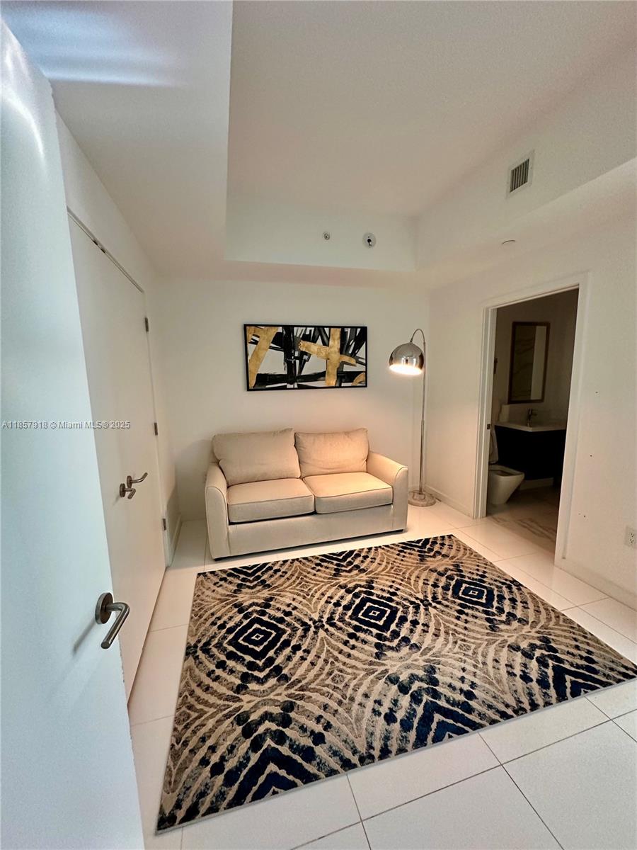 851 Northeast 1st Avenue, Unit 1106 Miami, FL 33132 - Photo 12 of 15 a bedroom with a bed and a couch