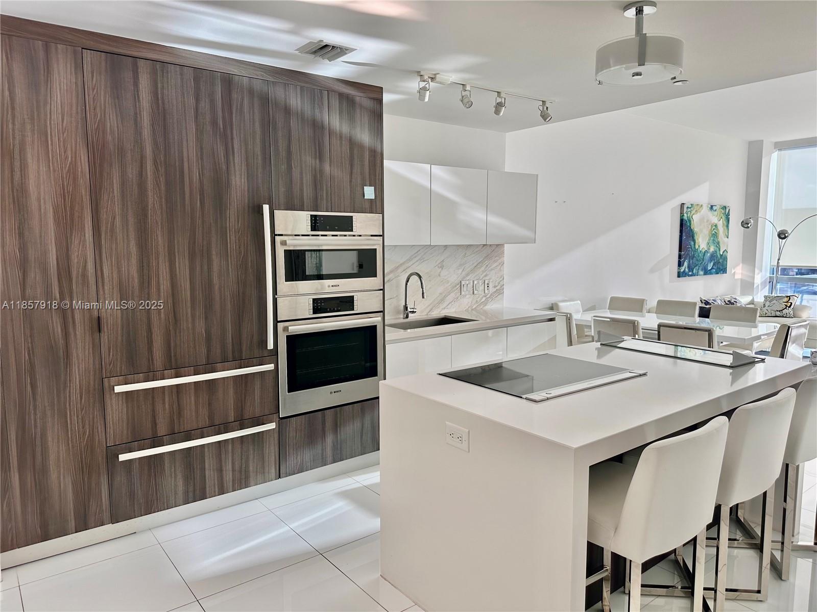 851 Northeast 1st Avenue, Unit 1106 Miami, FL 33132 - Photo 3 of 15 a kitchen with stainless steel appliances kitchen island granite countertop a sink and cabinets
