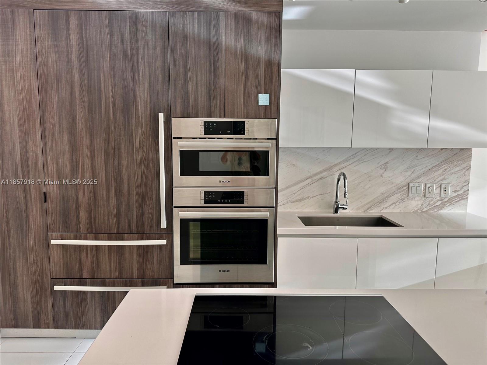 851 Northeast 1st Avenue, Unit 1106 Miami, FL 33132 - Photo 5 of 15 a kitchen with a sink and a stove top oven