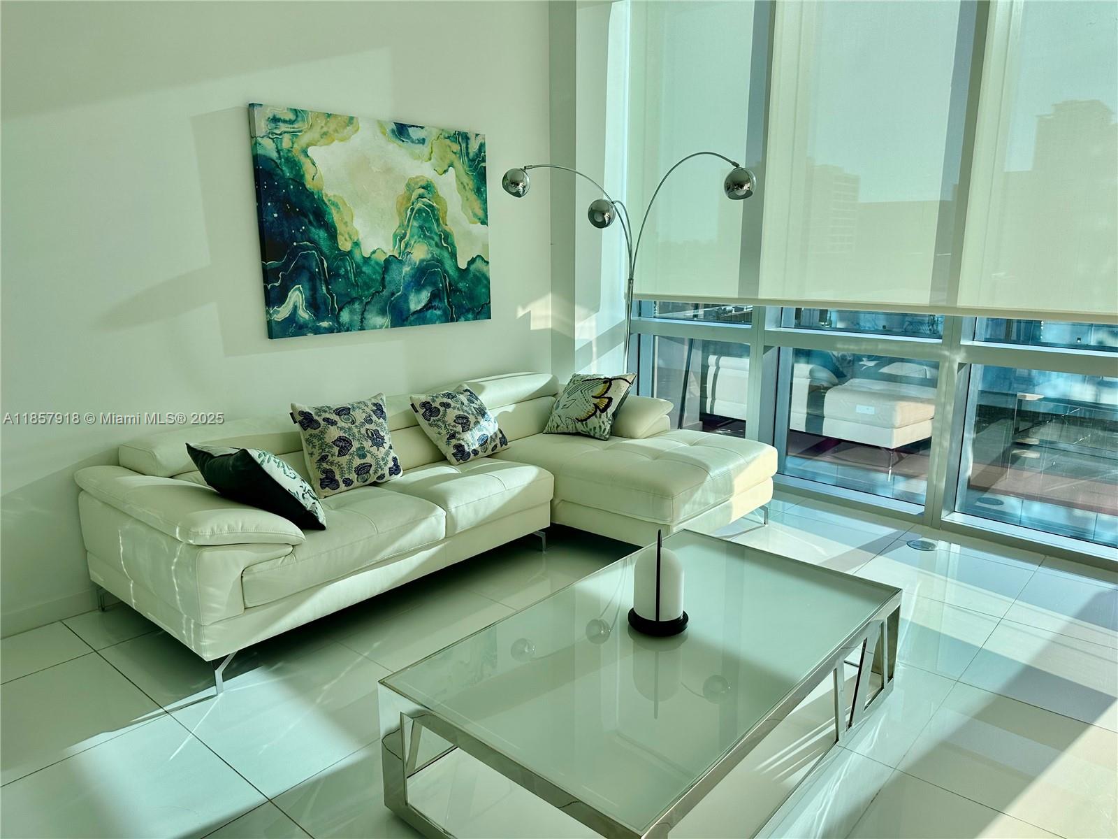 851 Northeast 1st Avenue, Unit 1106 Miami, FL 33132 - Photo 6 of 15 a living room with furniture and a potted plant