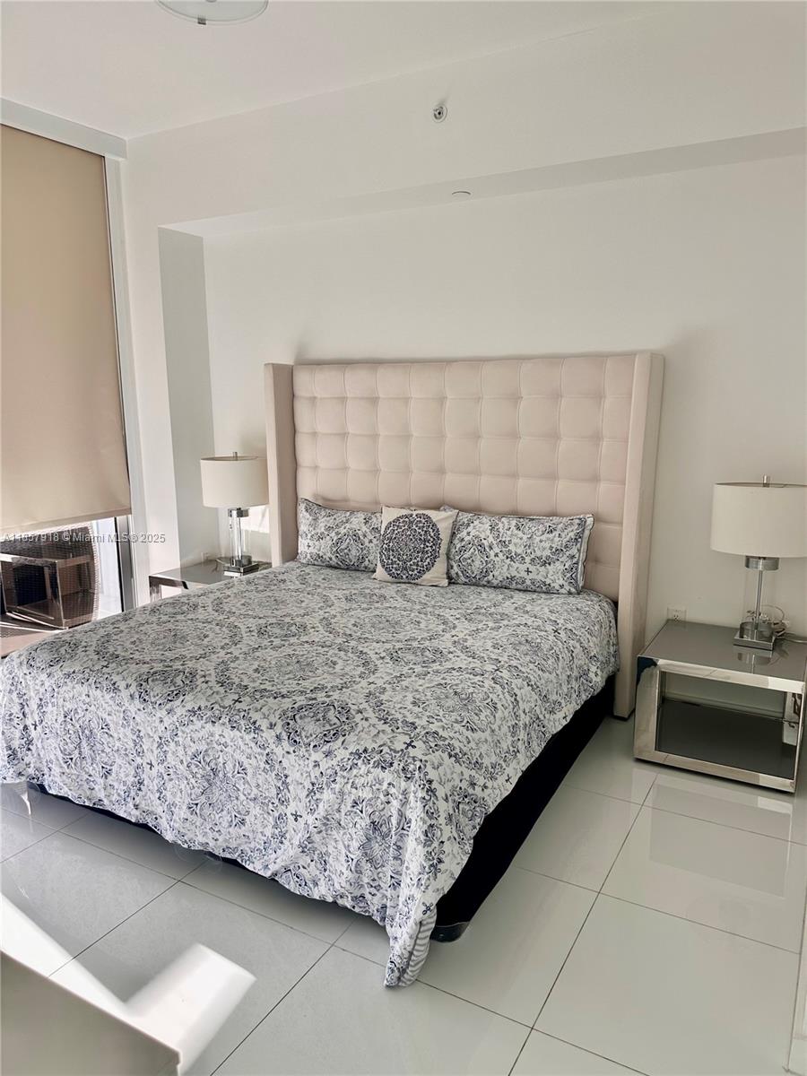 851 Northeast 1st Avenue, Unit 1106 Miami, FL 33132 - Photo 7 of 15 a bedroom with a bed and a couch