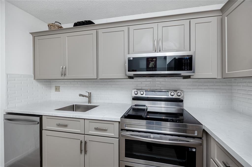 2207 Belleair Road, Unit B30 Clearwater, FL 33764 - Photo 4 of 39 a kitchen with cabinets stainless steel appliances and a sink