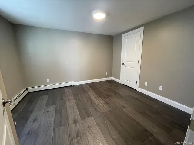a view of a room with wooden floor and white walls