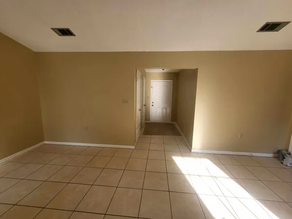 a view of a livingroom with an empty space and a window