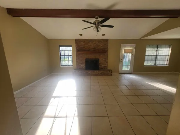 a view of empty room with a fireplace and windows