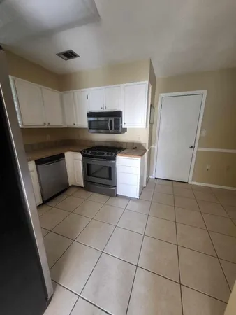a kitchen with a sink a stove and cabinets