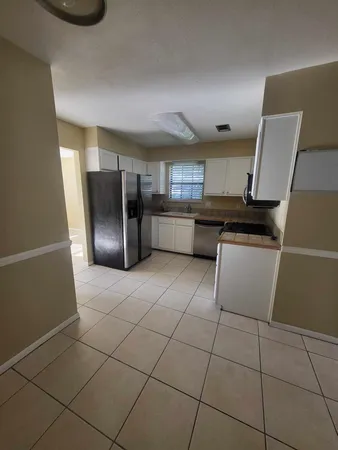 a kitchen with stainless steel appliances a refrigerator a sink a stove top oven a counter space and cabinets