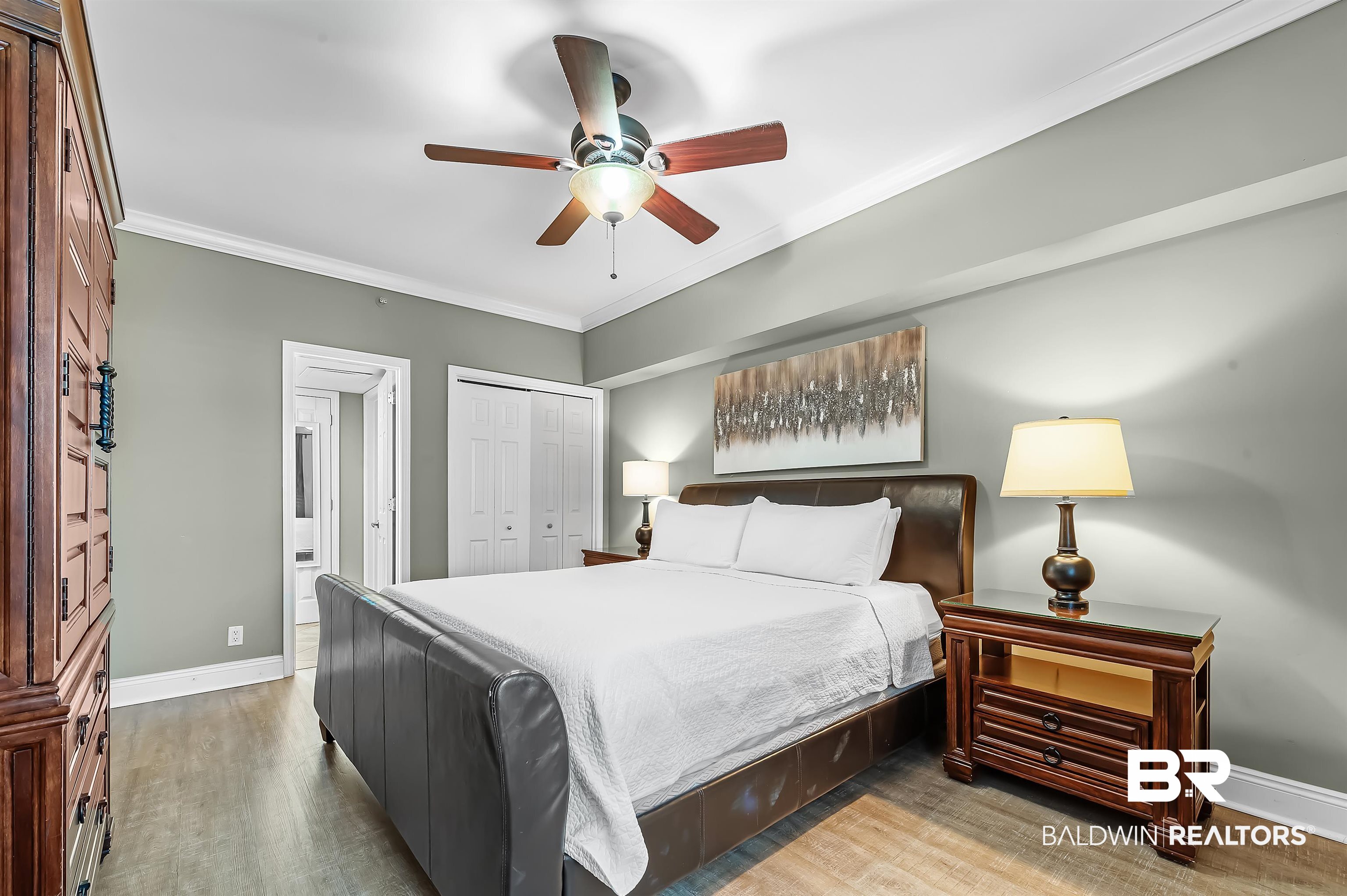 16287 Perdido Key Drive, Unit 105 Pensacola, FL 32507 - Photo 29 of 66 Bedroom featuring wood-finish flooring, a ceiling fan with integrated lighting, and crown molding
