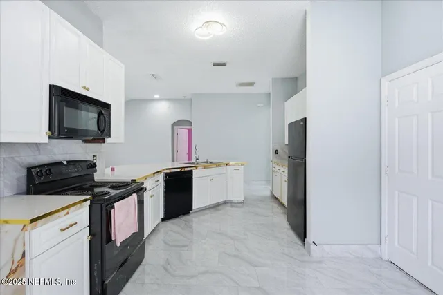 a kitchen with a stove a sink and a microwave