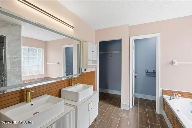 a white bath tub sitting in a bathroom next to a window